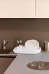 neutral coloured dish rack made by magis design in kitchen next to sink