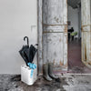 magis poppins umbrella stand in white with a black umbrella, a small light blue umbrella and a pair of black and white checkered wellies | shop at ikonitaly