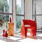 magis raviolo ron arad red chair in polyethylene next to a standing log of wood with a vase on top | ikonitaly