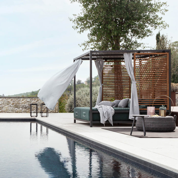 Modern outdoor cabana daybed by the pool with sea view — luxury garden furniture.