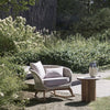 Ludo L6 patio rocking chair placed in a garden, illustrating its suitability for outdoor relaxation.