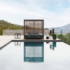 Perspective of the Alcova daybed next to a pool highlighting the modular teak panels and ergonomic cushions.