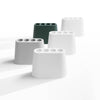 B Line Aki umbrella stands in various colors, including white, light grey, and red, shown side by side to highlight available options.