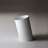 in attesa, a white waste paper bin with an informal base, sligtly tilted on one side, produced by danese milano