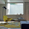 claritas, the magistretti floor lamp by nemo in a living room with a lounge chair, footstool and low table