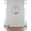 beautiful round mirror in inflated steel with a hole in the middle hung on a wall in a museum